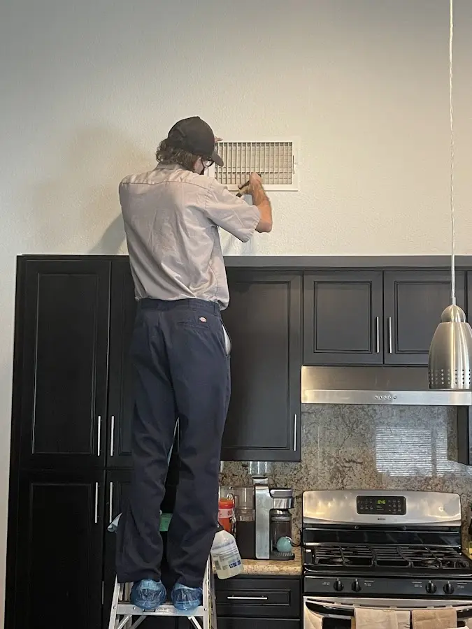 Technician inspecting an air vent during HVAC service in East Cocalico